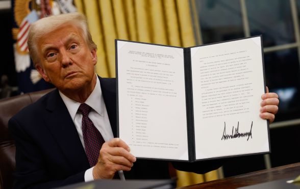 US President Donald Trump holding up an executive order after his inauguration on Monday 20 January 2025