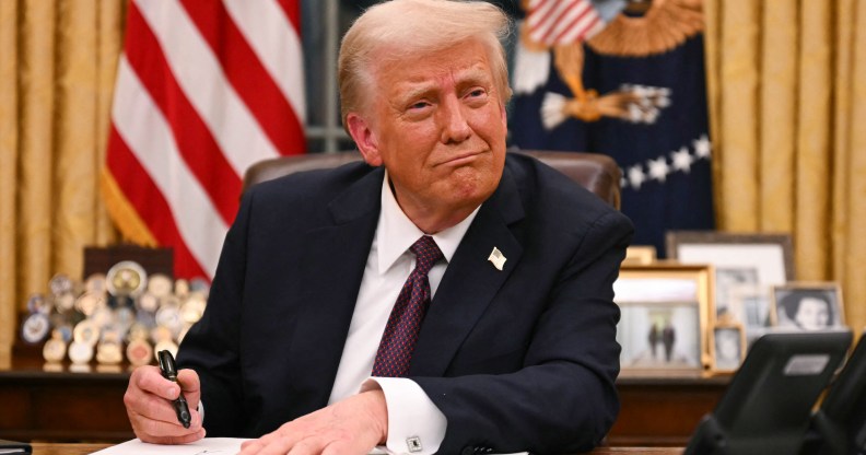 US President Donald Trump signs executive orders in the Oval Office of the White House in Washington, DC, on January 20, 2025. (Photo by Jim WATSON / AFP)