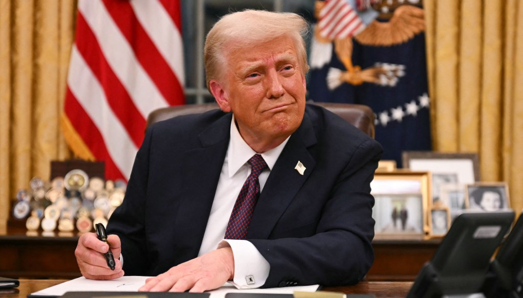 US President Donald Trump signs executive orders in the Oval Office of the White House in Washington, DC, on January 20, 2025. (Photo by Jim WATSON / AFP)