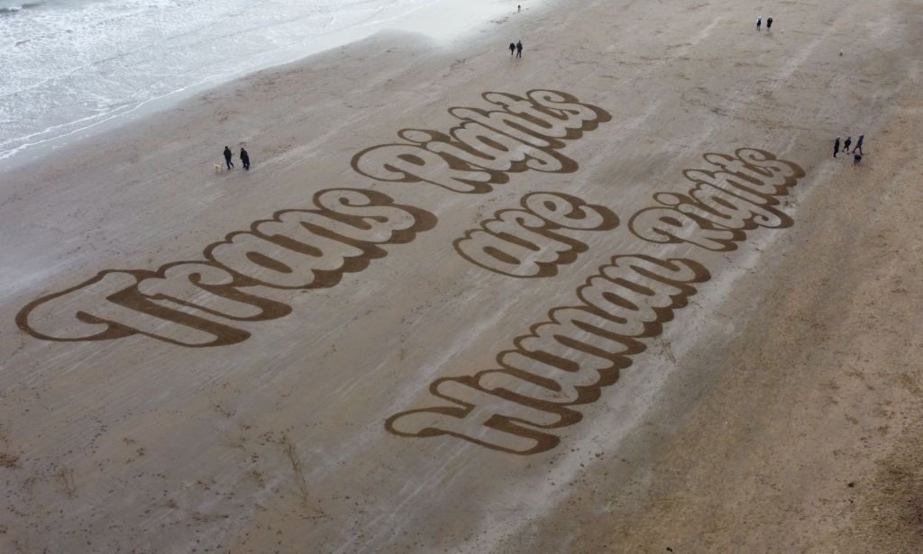 Trans rights are human rights written on a beach