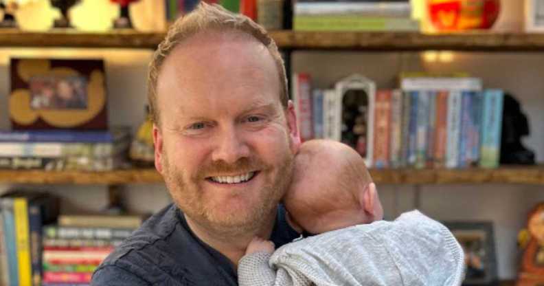 Kevin smiles as he holds his baby girl close to him.