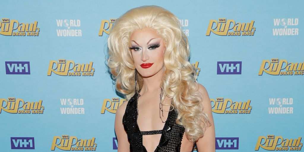 Lady Camden at the final of Drag Race season 14 on the red carpet wearing a big blonde wig and black dress