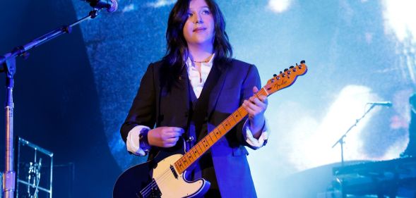 Musician Lucy Dacus performs on stage with an electric guitar