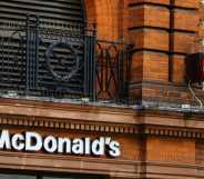 Pedestrians passing in front of a Mc Donald's restaurant on the main street of London, United Kingdom.