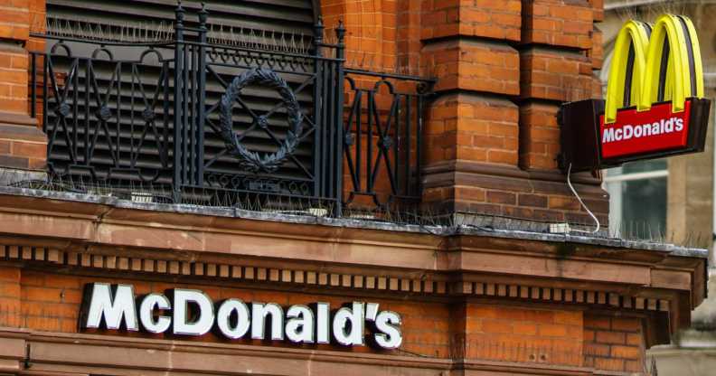 Pedestrians passing in front of a Mc Donald's restaurant on the main street of London, United Kingdom.