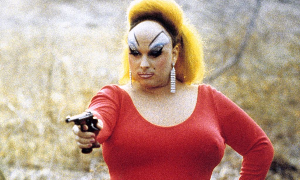 Divine holding a gun.