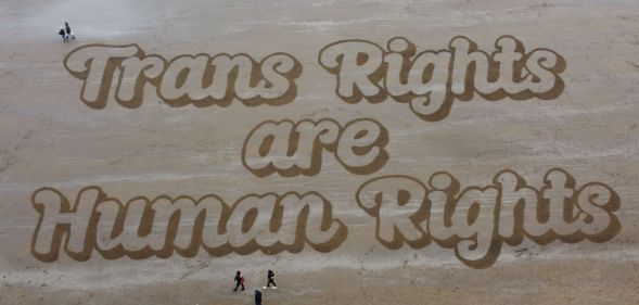 A sand mural that reads: "Trans Rights are Human Rights."