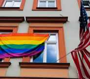 pride flag is hanging next to the US national flag over the entrance to the the U.S. Consulate General in Krakow, Poland