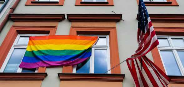 pride flag is hanging next to the US national flag over the entrance to the the U.S. Consulate General in Krakow, Poland