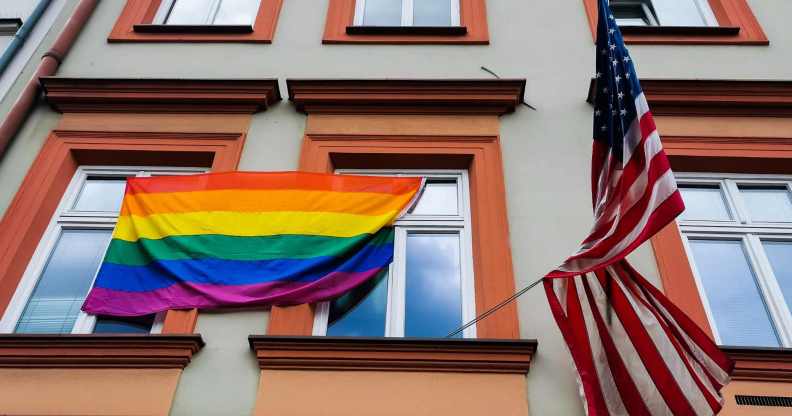 pride flag is hanging next to the US national flag over the entrance to the the U.S. Consulate General in Krakow, Poland