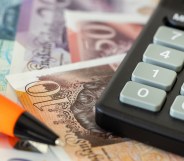 British bank notes next to a calculator and pen