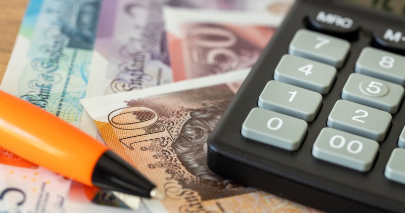 British bank notes next to a calculator and pen