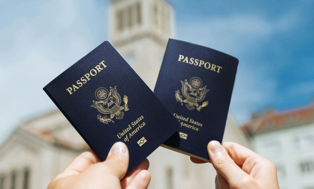 Two hands holding two USA passports