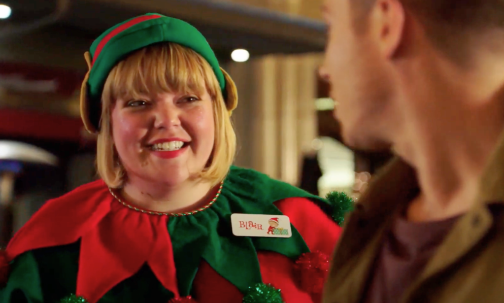 A smiling elf at santa's grotto.