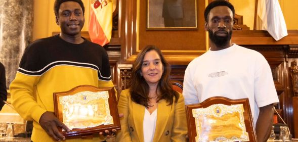 Ibrahima Diack and Magatte N'Diaye stand beside Mayor Inés Rey after being honoured by Spanish city A Coruña