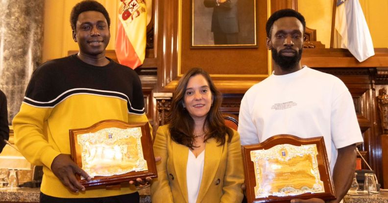 Ibrahima Diack and Magatte N'Diaye stand beside Mayor Inés Rey after being honoured by Spanish city A Coruña