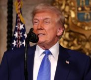 US President Donald Trump stands behind a microphone at a podium