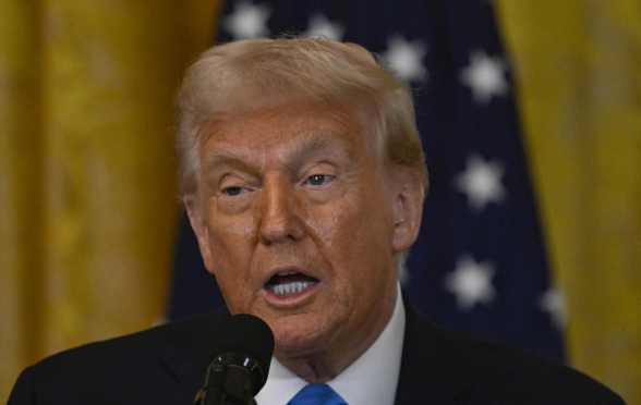 US president Donald Trump with a US flag behind him