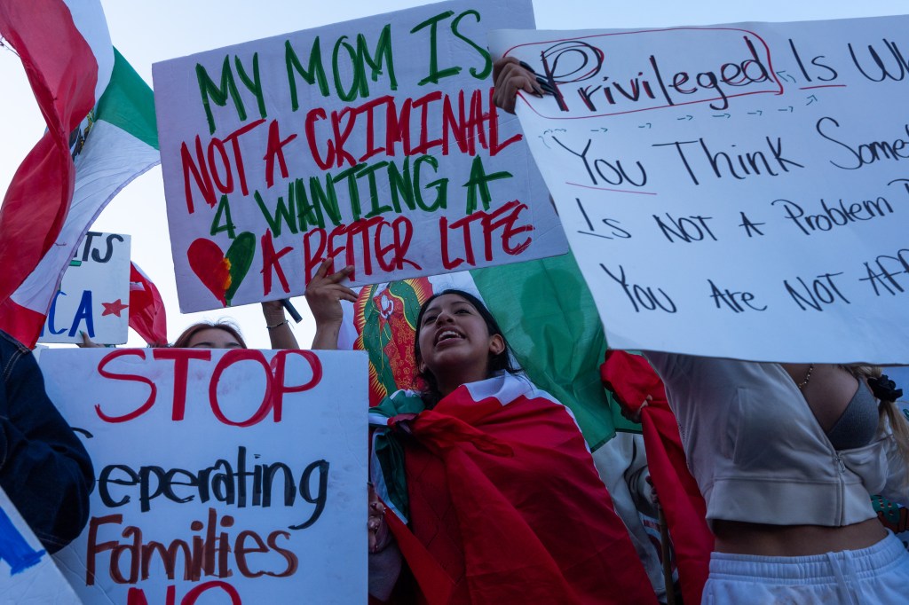 Protestors holding signs against immigration policies