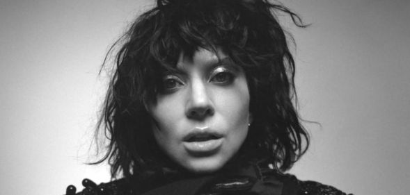 Lady Gaga in a black wig, her face close to the camera, in black and white for the cover of her album Mayhem.