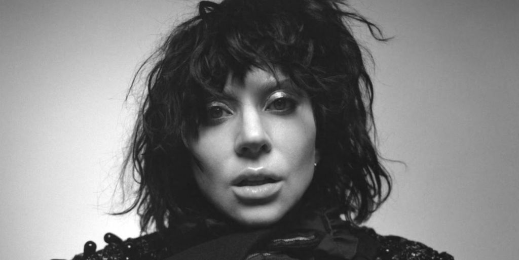 Lady Gaga in a black wig, her face close to the camera, in black and white for the cover of her album Mayhem.