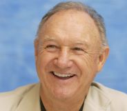 The Birdcage star Gene Hackman smiling against a blue background.