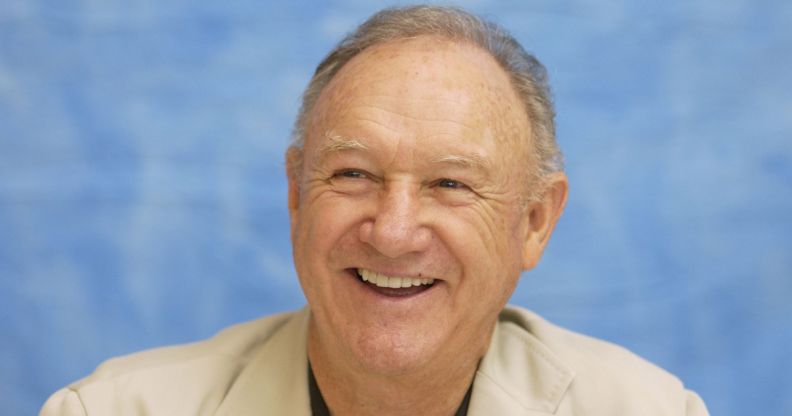 The Birdcage star Gene Hackman smiling against a blue background.