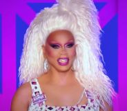 A still of RuPaul smiling during a performance on Drag Race UK season 3