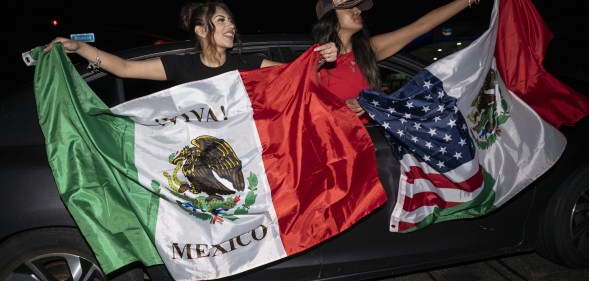 Two women holding Mexican flags at L.A protests against Trump immigration policies