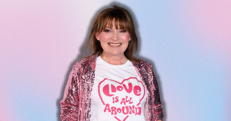 Lorraine Kelly smiling wearing a pink glittery coat and a 'love is all around' t-shirt, she is imposed against a pink and blue background.