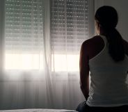 Stock image of a domestic abuse victim sitting with their back to the camera