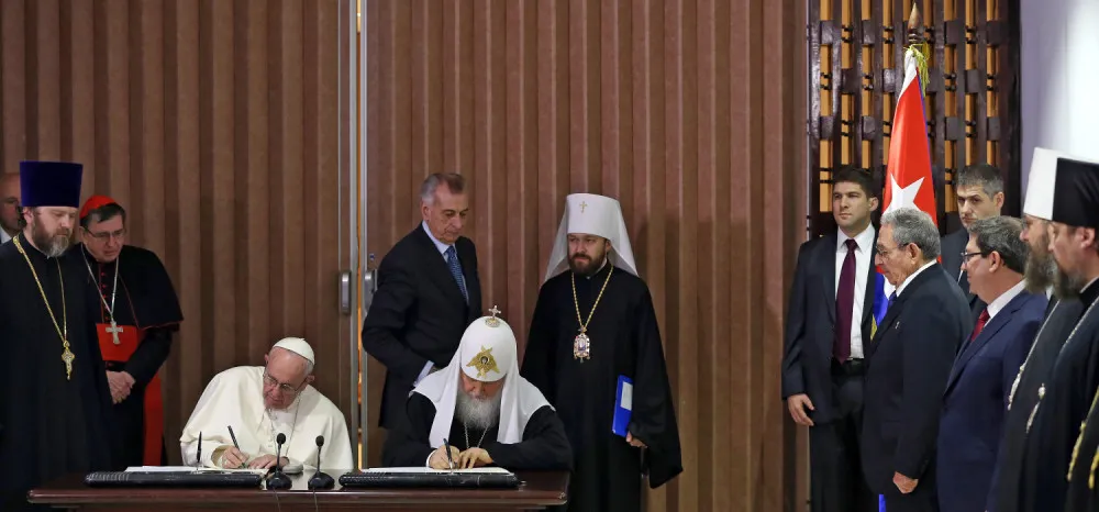 Pope Francis (L) and the head of the Russian Orthodox Church, Patriarch Kirill (C), sign documents after a historic meeting next to Cuban President Raul Castro (4-R) in Havana on February 12, 2016. Pope Francis and Russian Orthodox Patriarch Kirill kissed each other and sat down together Friday at Havana airport for the first meeting between their two branches of the church in nearly a thousand years. AFP PHOTO / POOL - Alejandro Ernesto / AFP / POOL / ALEJANDRO ERNESTO (Photo credit should read ALEJANDRO ERNESTO/AFP/Getty Images)