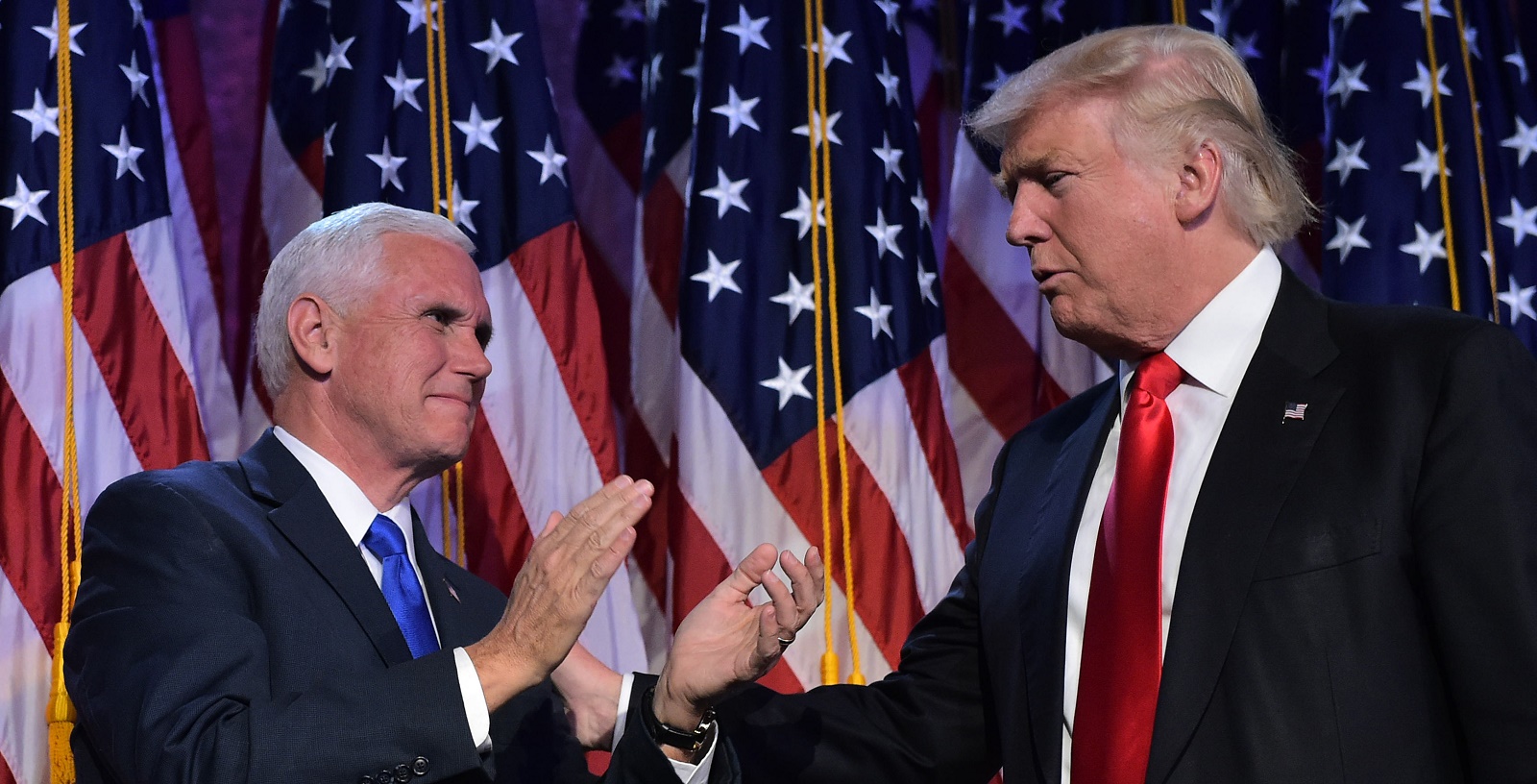 Republican presidential elect Donald Trump (R) reaches to his Vice President elect Mike Pence during election night at the New York Hilton Midtown in New York on November 9, 2016. Trump stunned America and the world Wednesday, riding a wave of populist resentment to defeat Hillary Clinton in the race to become the 45th president of the United States. / AFP / MANDEL NGAN (Photo credit should read MANDEL NGAN/AFP/Getty Images)