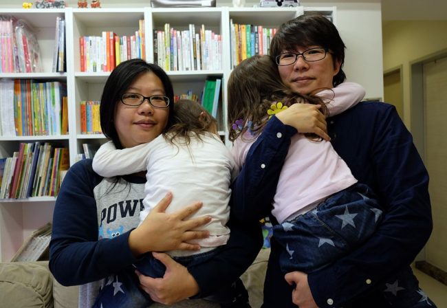 Same-sex parents Hope Chen (L), 37, and Zoro Wen, 34, posing with their twin daughters