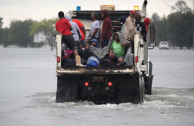 PORT ARTHUR, TX - AUGUST 30:  Evacuees ride on a truck after they were driven from their homes by the flooding from Hurricane Harvey on August 30, 2017 in Port Arthur, Texas. Harvey, which made landfall north of Corpus Christi late Friday evening, is expected to dump upwards to 40 inches of rain in Texas over the next couple of days.  (Photo by Joe Raedle/Getty Images)