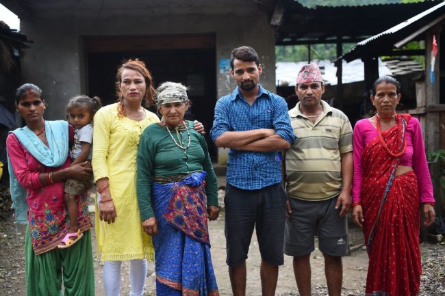 This photo taken on August 23, 2017 shows Nepali transgender person Monika Shahi Nath (3rd L) with Laxmi Giri Nath (L), the first wife of her husband Ramesh Nath Yogi (3rd R), Ramesh's youngest daughter Nabin Nath (2nd), Ramesh's grandmother-in-law Parbati Devi Nath (C), Ramesh's father-in-law Bhawani Nath (2nd) and Ramesh's mother-in-law Sita Devi Nath (R) in Kain Pani village in Nepal's Dadeldhura district. Monika Shahi Nath, 40, became Nepal's first transgender person to be issued with a marriage certificate by district officials when she married 22-year-old Ramesh Nath Yogi in May, even though Nepal has no formal laws for such unions. The couple have found a rare acceptance in Nepal, where many transgender people still struggle to be open about their identity despite progressive laws that include a third gender option on identity cards and passports. / AFP PHOTO / Prakash MATHEMA / TO GO WITH Nepal-transgender-marriage-rights        (Photo credit should read PRAKASH MATHEMA/AFP/Getty Images)