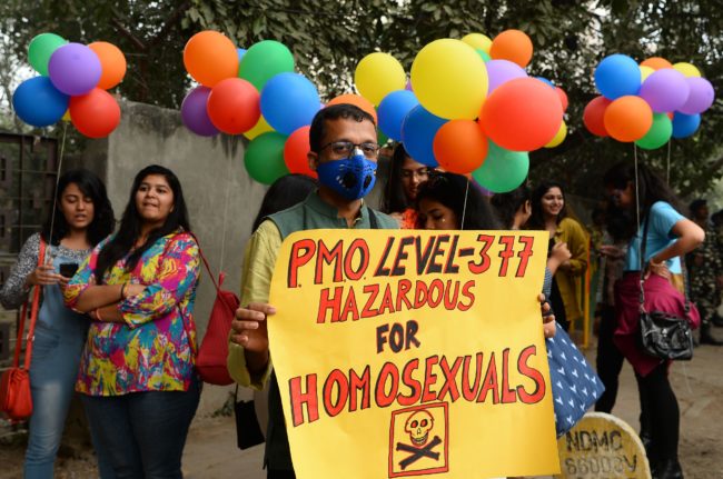 An Indian supporter of the lesbian, gay, bisexual, transgender (LGBT) community wearing a pollution mask hold a placard as he takes part in a pride parade in New Delhi on November 12, 2017. Hundreds of members of the LGBT community marched through the Indian capital for the 10th annual Delhi Queer Pride Parade.   / AFP PHOTO / SAJJAD HUSSAIN        (Photo credit should read SAJJAD HUSSAIN/AFP/Getty Images)