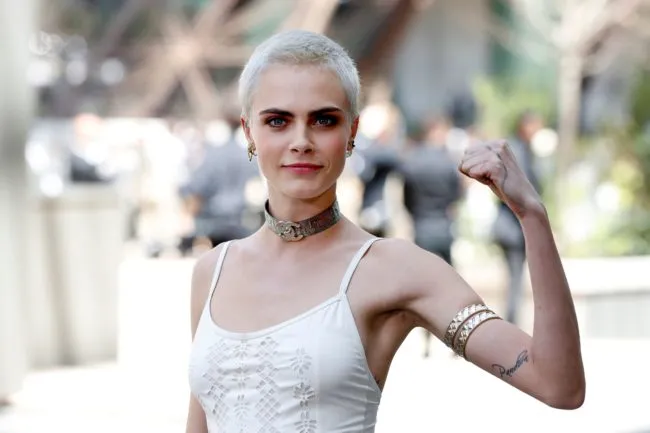 British model and actress Cara Delevingne poses during the photocall before Chanel 2017-2018 fall/winter Haute Couture collection show in Paris on July 4, 2017. / AFP PHOTO / Patrick KOVARIK (Photo credit should read PATRICK KOVARIK/AFP/Getty Images)