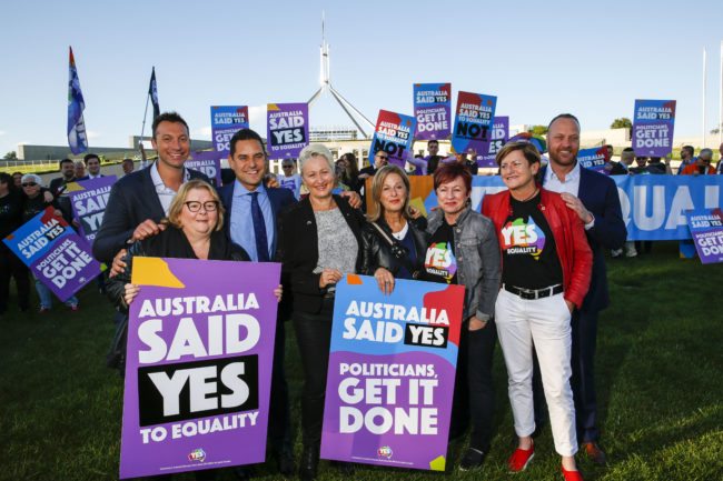Australian Olympic swimmer Ian Thorpe (L) joins equality ambassadors and volunteers from the Equality Campaign who gather in front of Parliament House in Canberra on December 7, 2017, ahead of the parliamentary vote on Same Sex Marriage, which will take place later today in the House of Representatives.   / AFP PHOTO / SEAN DAVEY