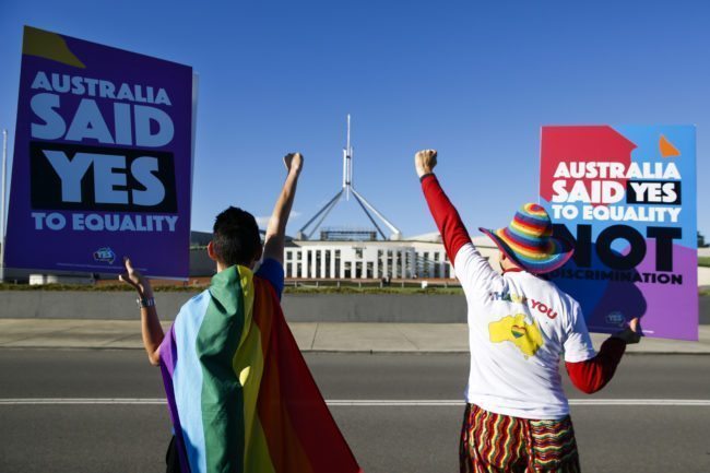 Equality ambassadors and volunteers from the Equality Campaign celebrate as they gather in front of Parliament House in Canberra on December 7, 2017, ahead of the parliamentary vote on Same Sex Marriage, which will take place later today in the House of Representatives. / AFP PHOTO / SEAN DAVEY