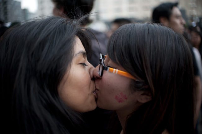 Activists and members of the Lesbian, Gay, Bisexual, Transgender, Transvestite, Transgender and Intersex (LGBTTTI) communities kiss during an activity for the International Day against Homophobia in front of the Palace of Fine Arts in Mexico City on May 17, 2016. / AFP / YURI CORTEZ (Photo credit should read YURI CORTEZ/AFP/Getty Images)