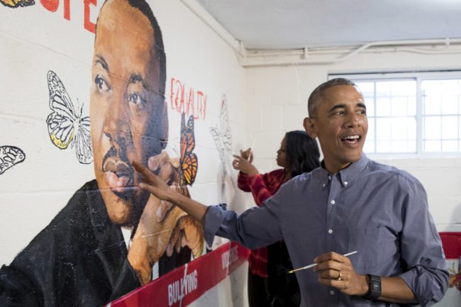 WASHINGTON, DC - JANUARY 16: (AFP OUT) U.S. President Barack Obama (Front) and first lady Michelle Obama (Back) help paint a mural depicting Martin Luther King Jr., at the Jobs Have Priority Naylor Road Family Shelter January 16, 2017 in Washington, DC. President Obama and the First Lady attended a service event at the Jobs Have Priority Naylor Road Family Shelter for Martin Luther King Jr. Day. (Photo by MICHAEL REYNOLDS-Pool/Getty Images)