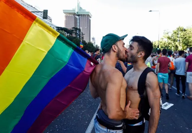 A couple kiss as one of them holds a rainbow flag the WorldPride 2017 parade in Madrid on July 1, 2017. Revellers took to the rainbow streets of Madrid today in the world's biggest march for gay, lesbian, bisexual and transgender rights. Carried along by the slogan "Viva la vida!" (Live life!), the parade of 52 floats started partying its way through the centre later afternoon in celebration of sexual diversity, under high security. / AFP PHOTO / OSCAR DEL POZO (Photo credit should read OSCAR DEL POZO/AFP/Getty Images)