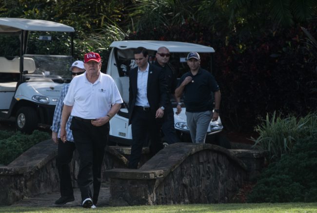 US President Donald Trump walks onto the green at the Trump International Golf Course in Mar-a-Lago, Florida during an invitation for United States Coast Guard service members to play golf on December 29, 2017. The President invited members of the Coast Guard to play golf to thank them personally for their service of patrolling the waters near Palm Beach and Mar-a-Lago. / AFP PHOTO / NICHOLAS KAMM (Photo credit should read NICHOLAS KAMM/AFP/Getty Images)