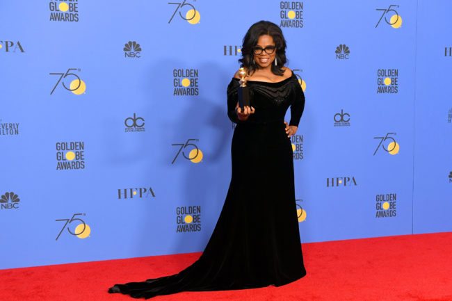 Oprah Winfrey poses with the Cecil B. DeMille Award (Photo by Kevin Winter/Getty Images)