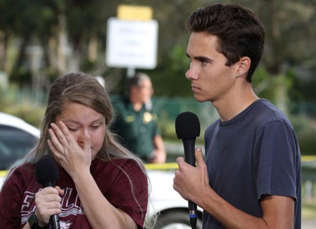 PARKLAND, FL - FEBRUARY 15: Students Kelsey Friend (L) and David Hogg recount their stories about yesterday's mass shooting at the Marjory Stoneman Douglas High School where 17 people were killed, on February 15, 2018 in Parkland, Florida. Police arrested the suspect after a short manhunt, and have identified him as 19 year old former student Nikolas Cruz. (Photo by Mark Wilson/Getty Images)