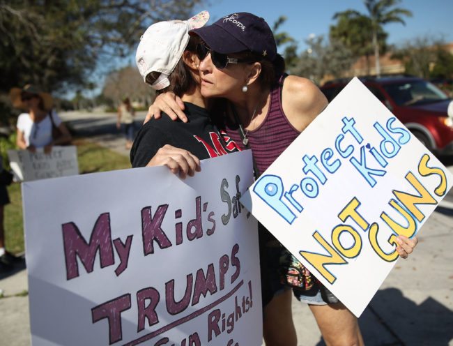 PARKLAND, FL - FEBRUARY 17:  Debby Stout (L) whose daughter was in the Marjory Stoneman Douglas High School when 17 people were killed is hugged by Lori Feldman during a protest against guns on February 17, 2018 in Parkland, Florida. Earlier this week former student Nikolas Cruz opened fire with a AR-15 rifle at the Marjory Stoneman Douglas High School killing 17 people.  (Photo by Joe Raedle/Getty Images,)
