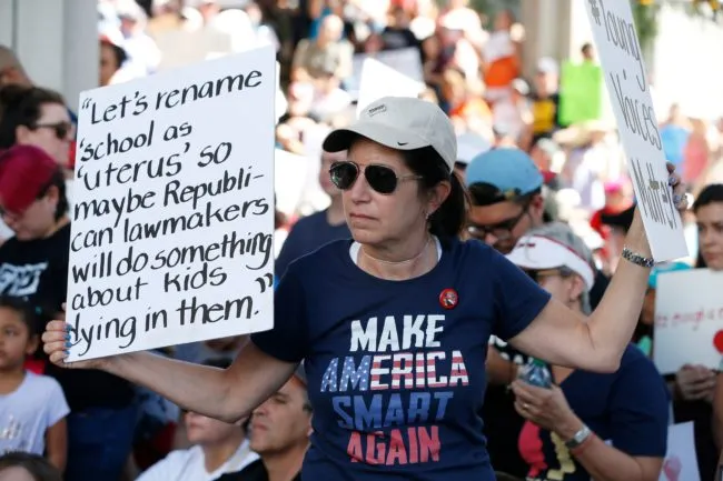 Protesters hold signs at a gun control at the Broward County Federal Courthouse in Fort Lauderdale, Florida on February 17, 2018.  Seventeen perished and more than a dozen were wounded in the hail of bullets at Marjory Stoneman Douglas High School in Parkland,Florida the latest mass shooting to devastate a small US community and renew calls for gun control. / AFP PHOTO / RHONA WISE        (Photo credit should read RHONA WISE/AFP/Getty Images)