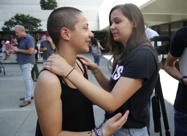 Marjory Stoneman Douglas High School student Emma Gonzalez is hugged by a friend following her speech at a rally for gun control at the Broward County Federal Courthouse in Fort Lauderdale, Florida on February 17, 2018. A former student, Nikolas Cruz, opened fire at the high school leaving 17 people dead and 15 injured on February 14.  / AFP PHOTO / RHONA WISE        (Photo credit should read RHONA WISE/AFP/Getty Images)