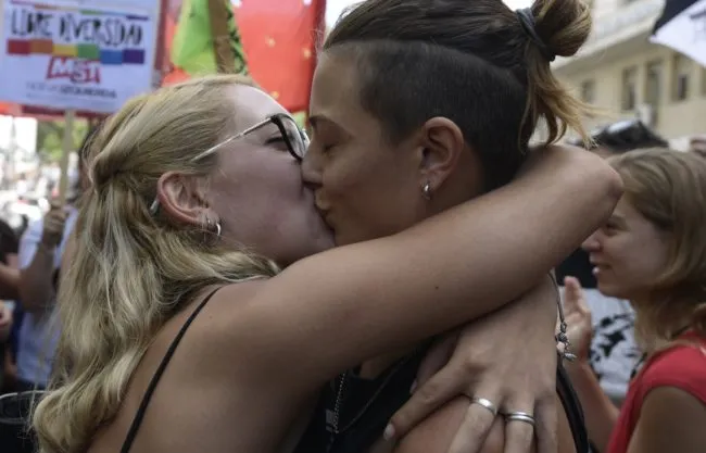 Mariana Gomez (R) and her wife Rocio Girat, kiss each other, during a protest in front of the court in Buenos Aires on February 6, 2018. People demonstrated in support of the matrimony of Mariana Gomez and Rocio Girat who reported a sexual orientation presecution by the Police after being arrested smoking in a no smoking area. / AFP PHOTO / JUAN MABROMATA (Photo credit should read JUAN MABROMATA/AFP/Getty Images)